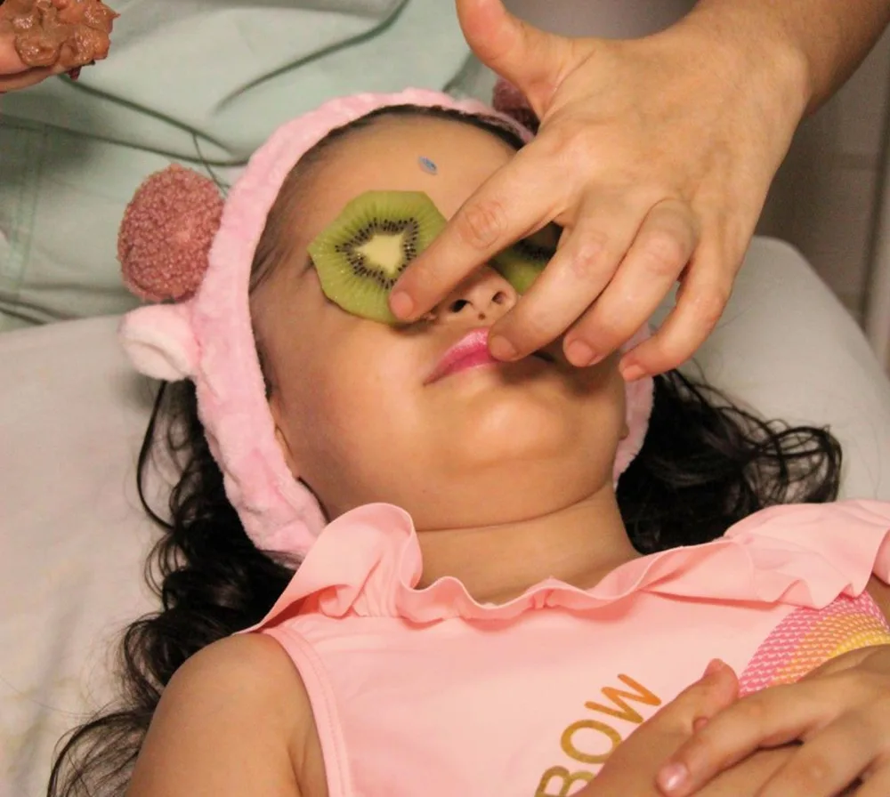 Facial infantil con rodajas de kiwi sobre los ojos en Daluma Spa