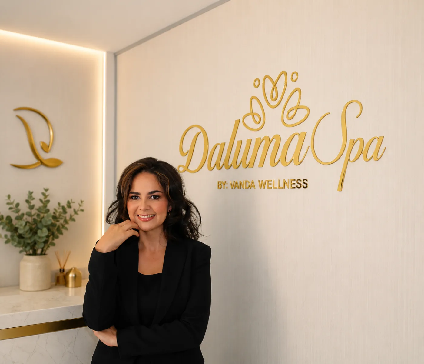Propietaria de Daluma Spa en la recepción, junto al logo de Daluma Spa by Vanda Wellness